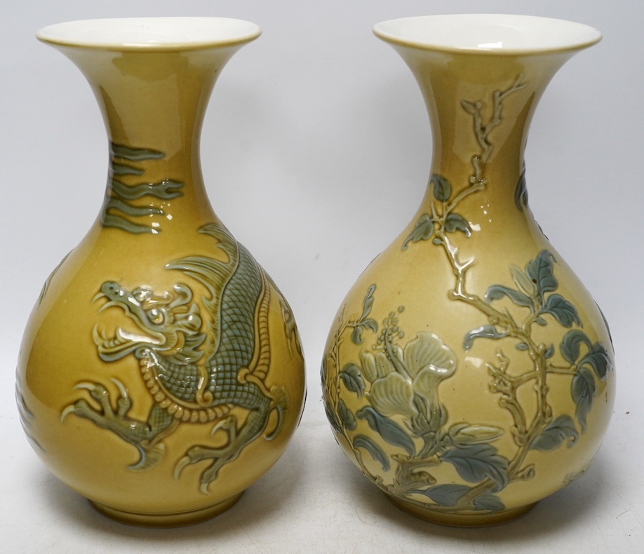 Two Lladro vases decorated in relief with dragons and birds, 26cm high. Condition - good